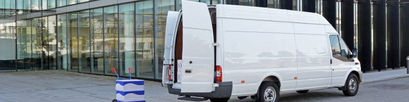 a van delivering parcels outside a commercial building