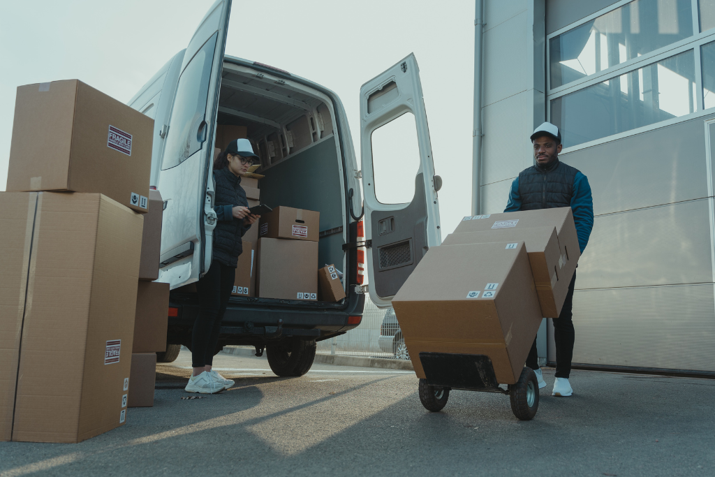 Delivery drivers moving boxes out the back of a van