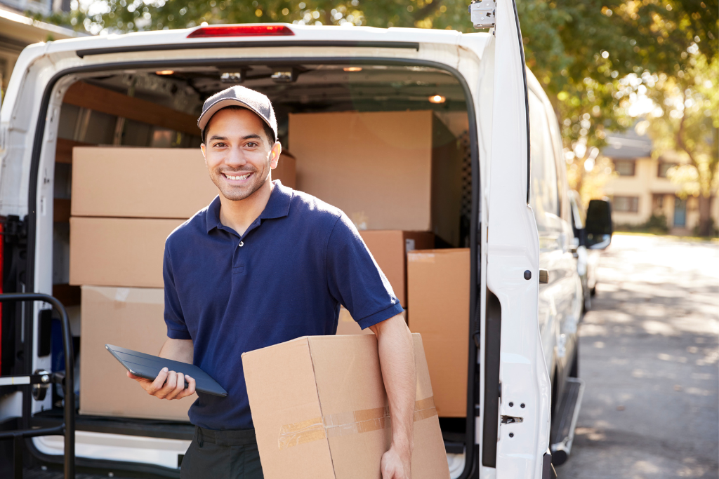 a man standing in front of a car or van with delivery boxes