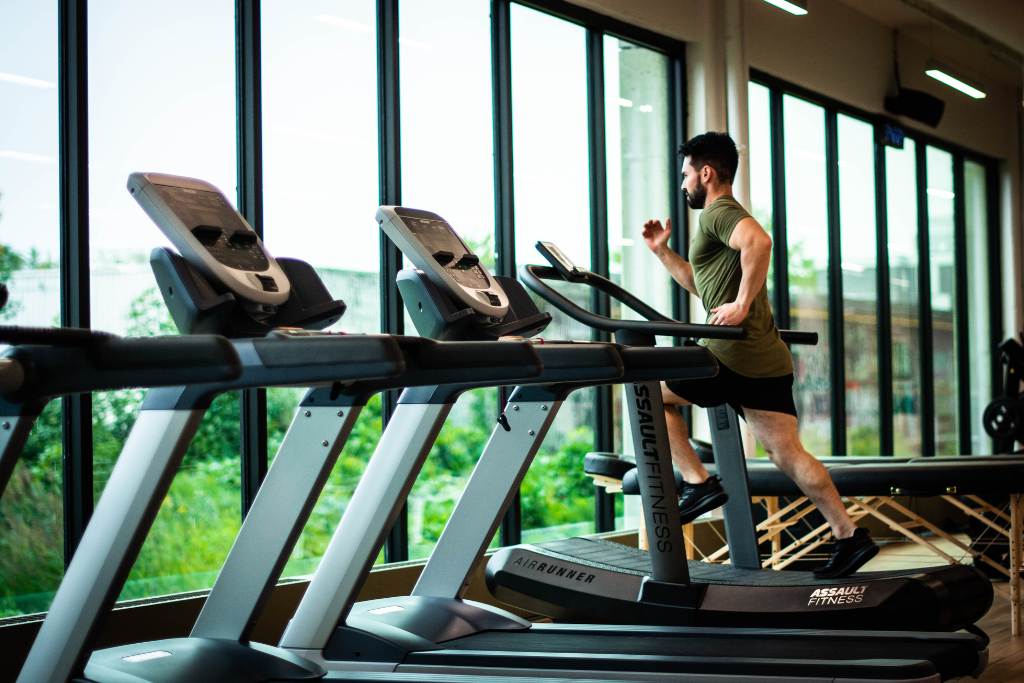 a person running on a treadmill with empty treadmills next to them