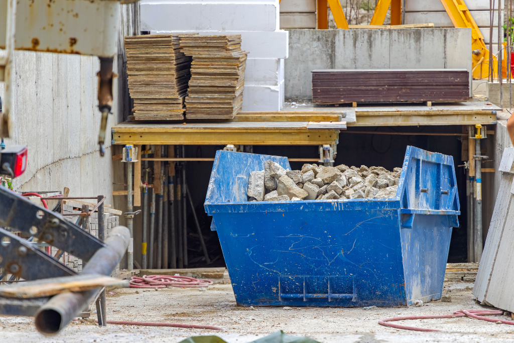 a blue skip on a building site filled with rubble