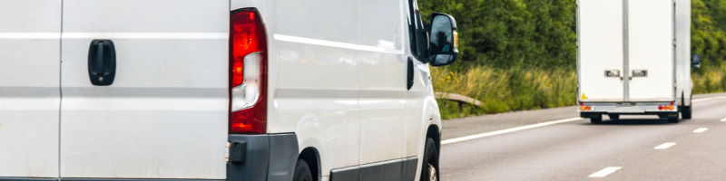 A van and a small lorry or larger van on a road driving